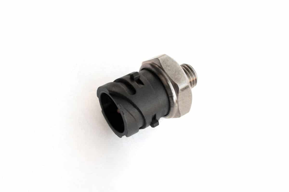 Oil pressure sensor of car isolated on white background. New spare parts. 