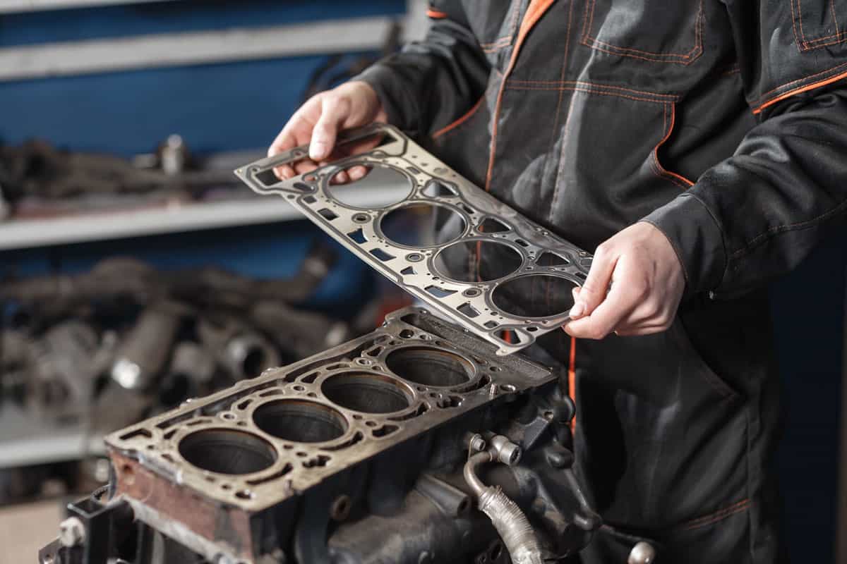Sealing gasket in hand. The mechanic disassemble block engine vehicle