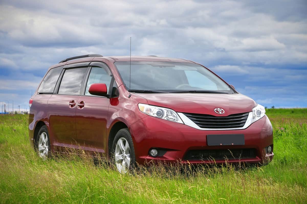 brand new Toyota sienna red paint on the middle of a grassy field