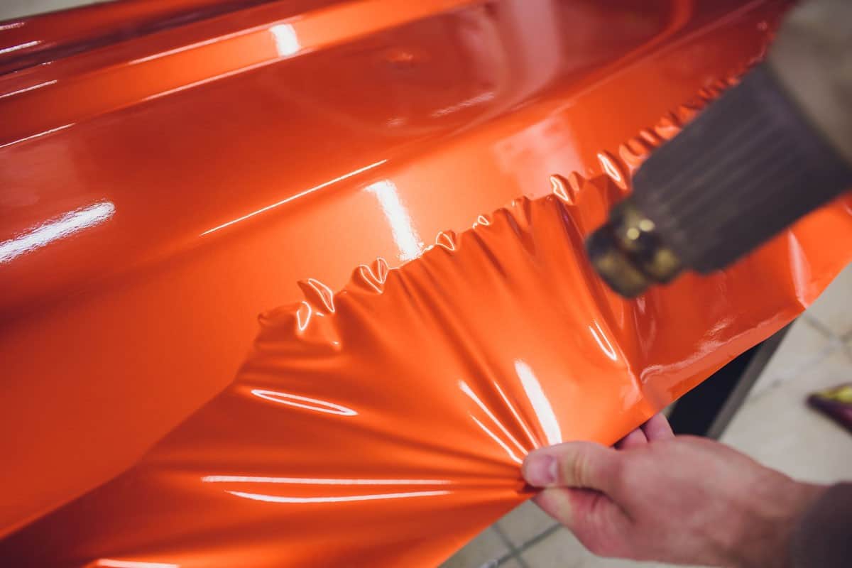 car wrapping specialist putting orange vinyl foil
