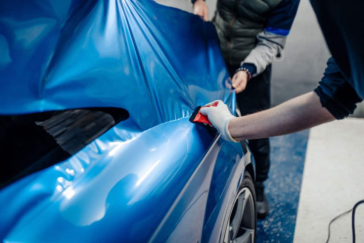car wrapping specialists putting blue vinyl foil