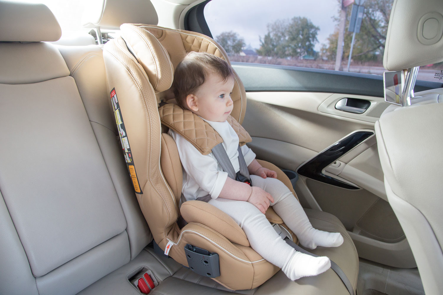 child in a baby car seat. Isofix clamping. beige car seat in a bright salon. Protection in the car. 