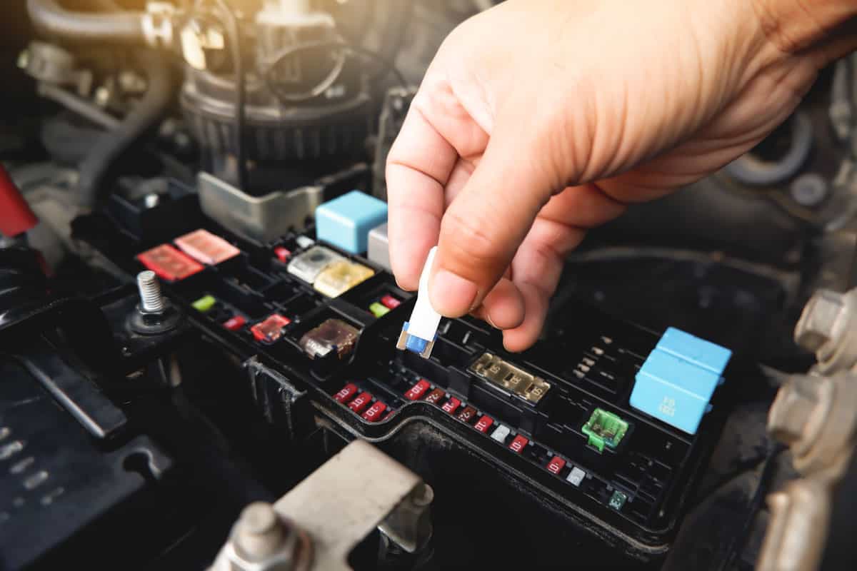 mechanic replaces spare fuse car box