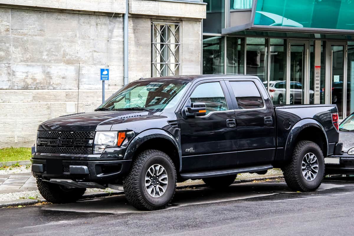 shiny glossy black Ford f150 parked on the road side parking