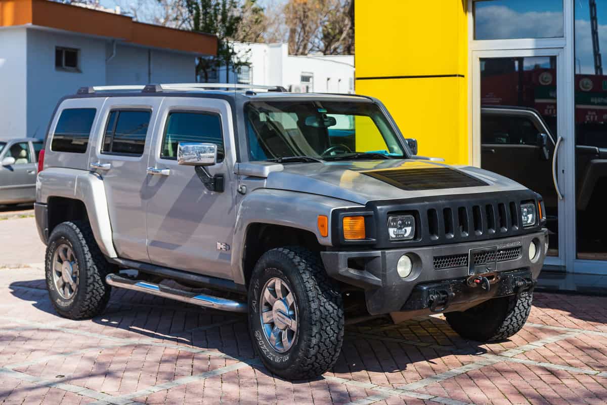 silver Hummer H3 is parked on the street on a warm summer day