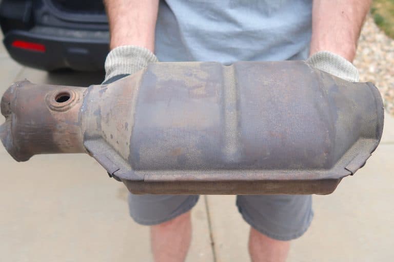 A large and rusty used catalytic converter that is removed from the vehicle, How Long Does It Take To Replace A Catalytic Converter?