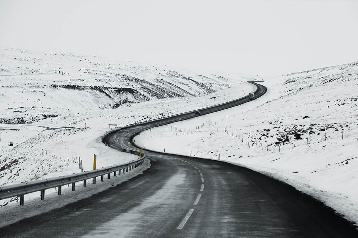 Asphalt road with sideways full of snow