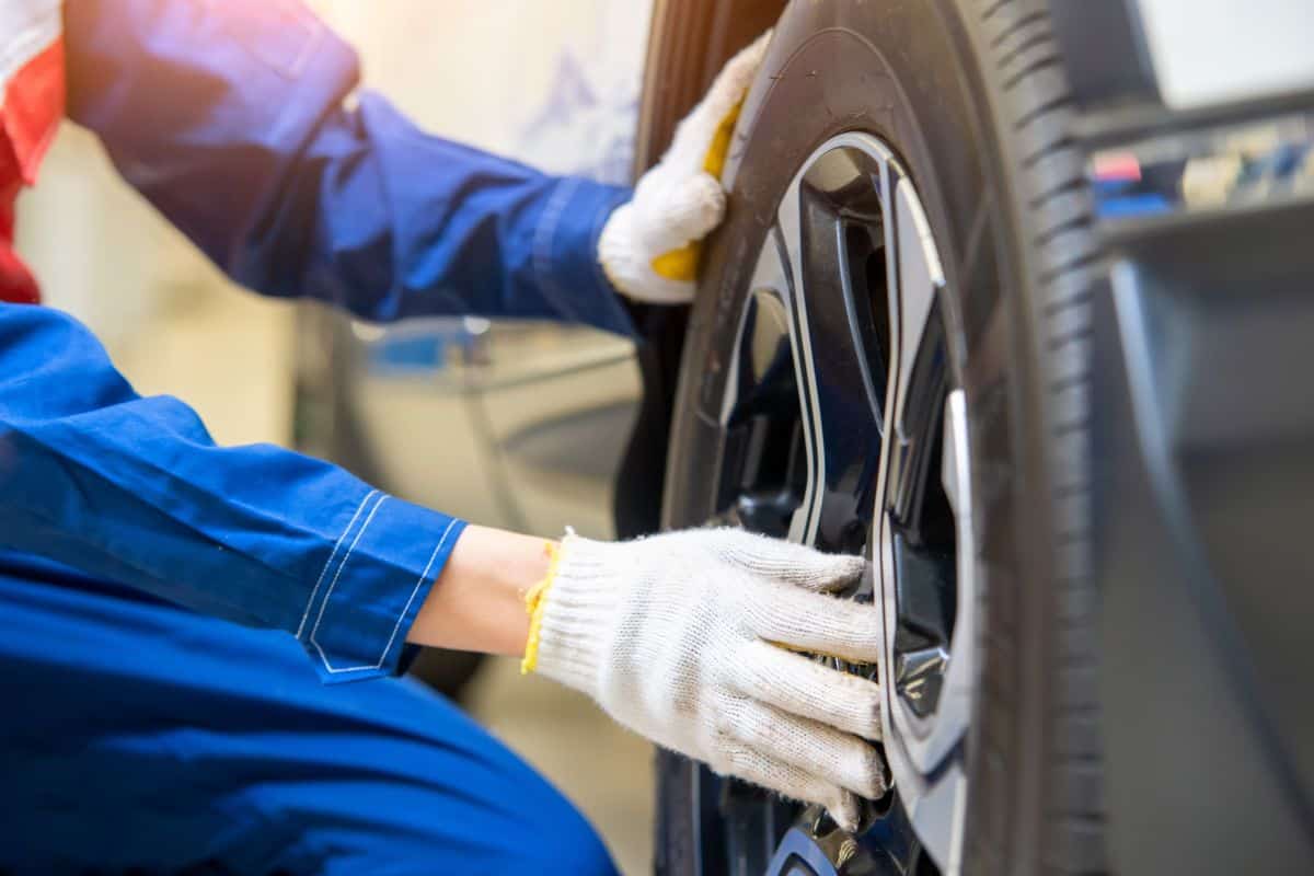Auto mechanic changing tire outside,Car service.Hands replace tires on wheels.Tire installation concept.