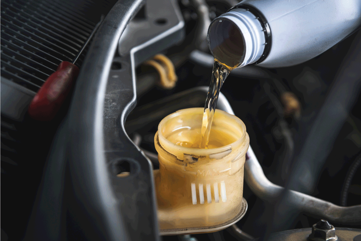Auto mechanic filling DOT 4 brake fluid in brake fluid reservoir. Hydraulic Fluid Vs Brake Fluid What's The Difference