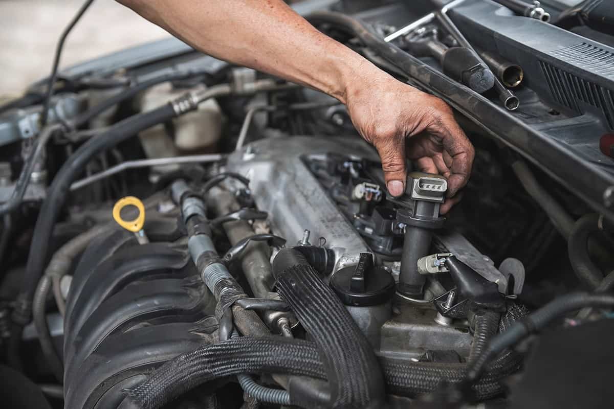 Auto mechanic testing and checking ignition coils