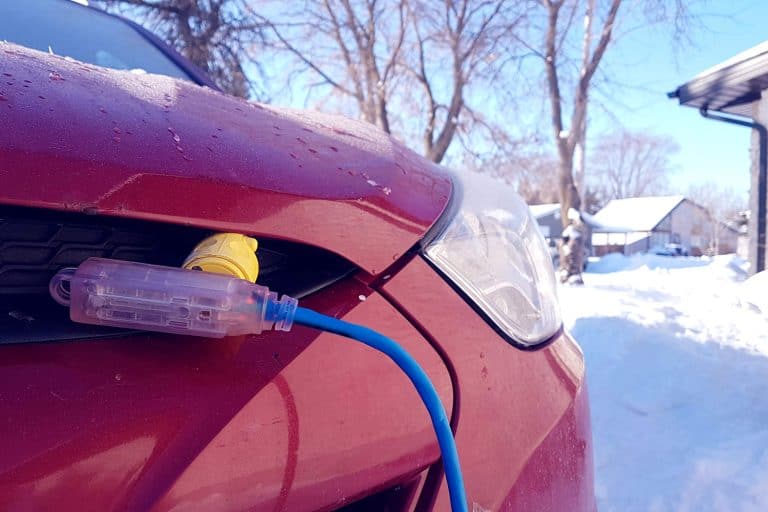 Block heater cable plugged into a vehicle parked in a snowy winter driveway, How Many Amps Does A Block Heater Draw?