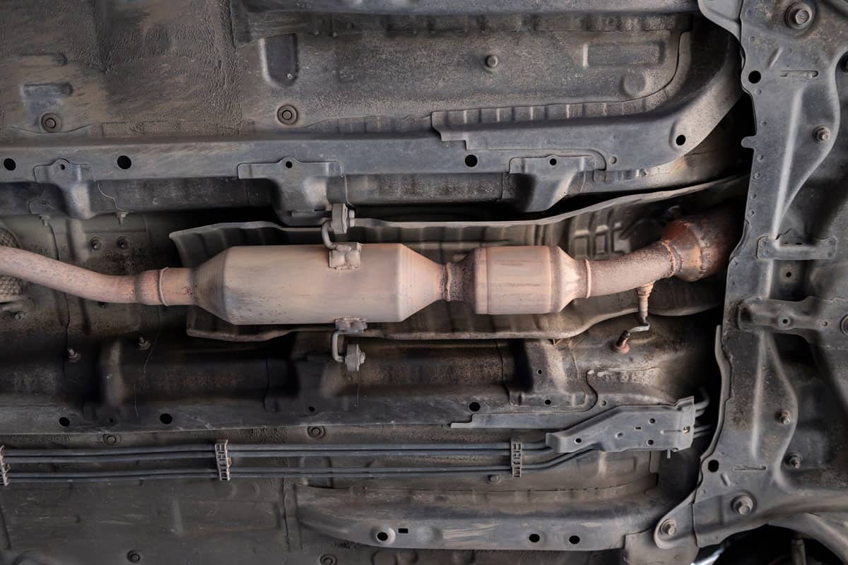 Close-up of Old Catalytic Converter and Resonator in Car Exhaust System.