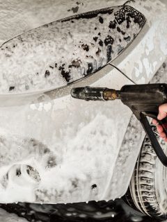 A washer holds a high pressure gun in his hand, Can You Use A Foam Cannon With A Garden Hose? [Tips For Detailing Your Car]