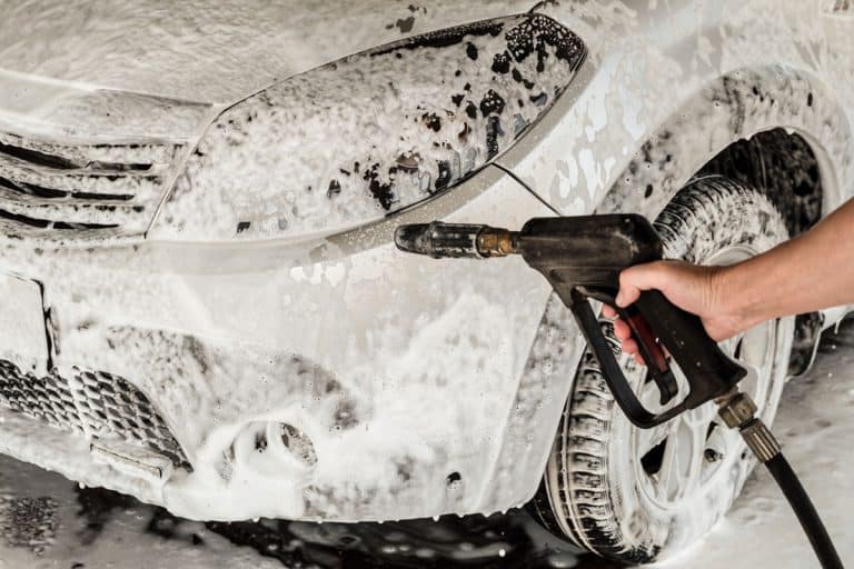 A washer holds a high pressure gun in his hand, Can You Use A Foam Cannon With A Garden Hose? [Tips For Detailing Your Car]