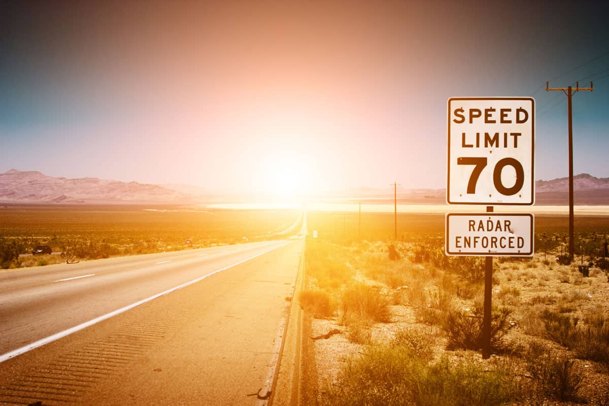 Highway road to sunset. 70 MPH speed limit sign