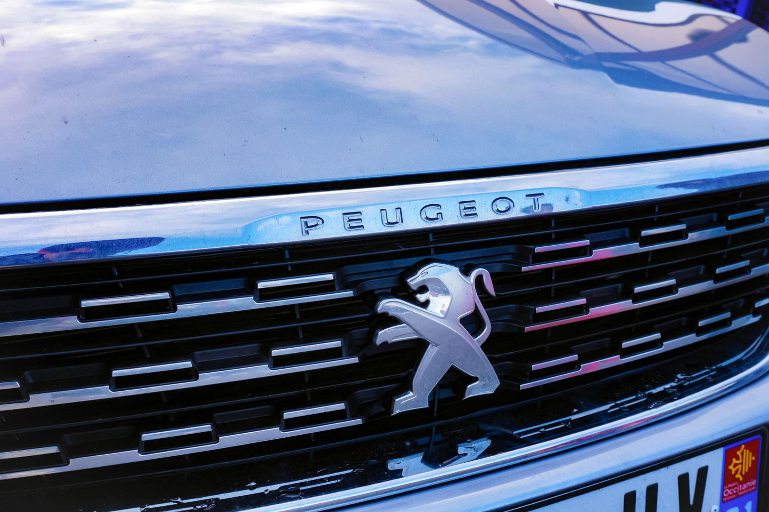  Modern design of the radiator grille of the New 308 hatchback car from the French manufacturer PSA Peugeot-Citroën, featuring the lion logo on the center and chrome fittings