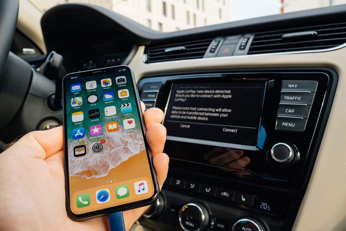 Man connecting his new iPhone X 10 to the navigation system of the car with CarPlay