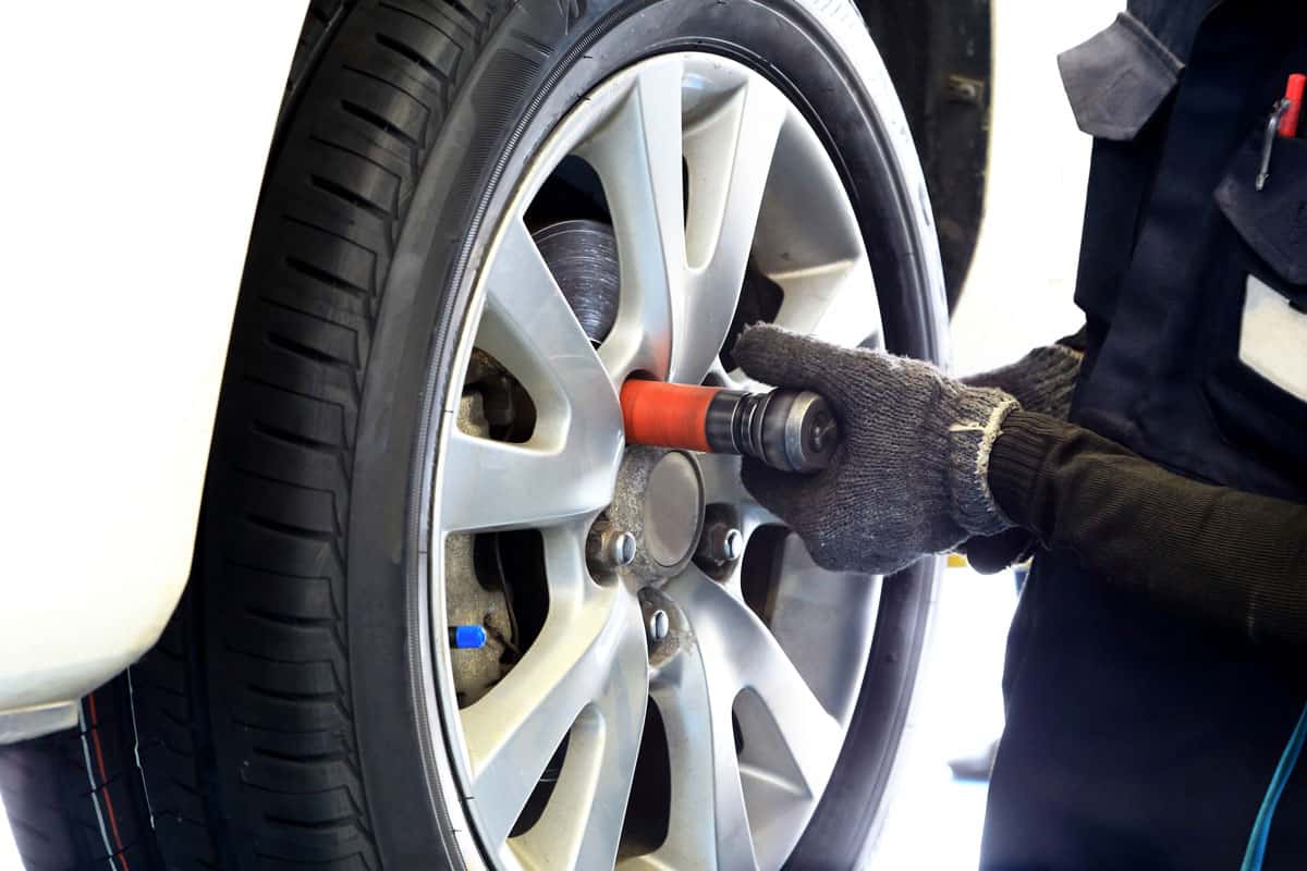 Mechanic using a torque wrench to remove the car tire