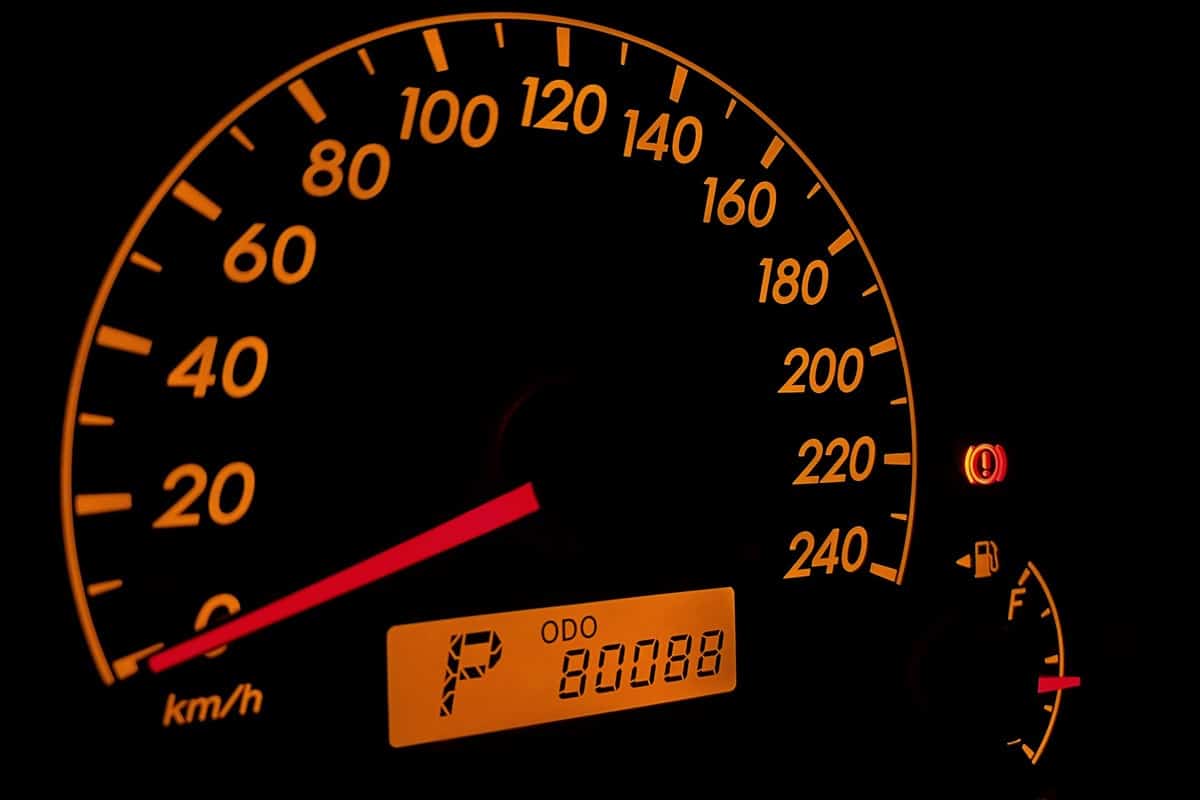 Orange colored vehicle dashboard with 80088 km odometer. 