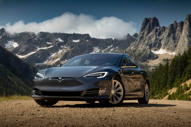 Photograph of a Tesla model 3 in front of a mountain in the wilderness, Tesla Model 3 Bearing Noise From Wheels - Why