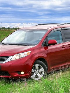 Red minivan Toyota Sienna in a grass field, How To Get The Jack Out Of A Toyota Sienna