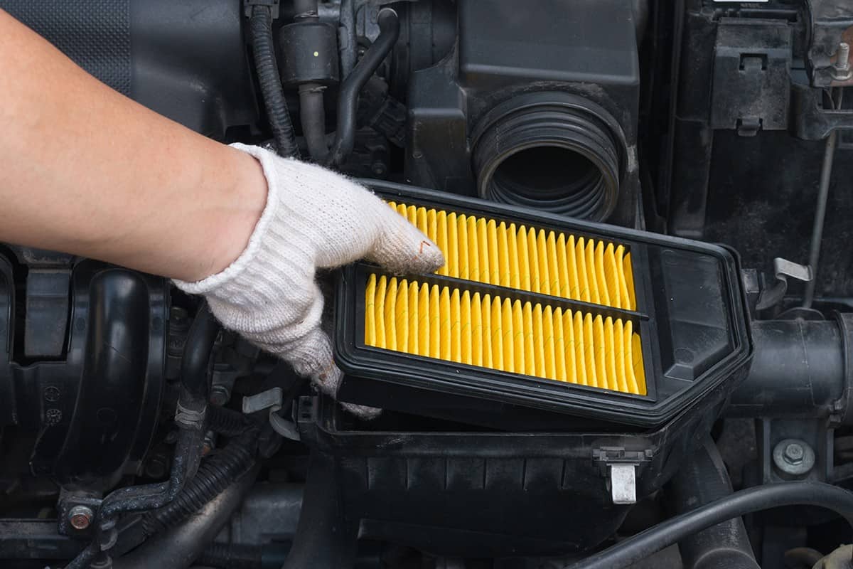 Technician is changing new air filter for car