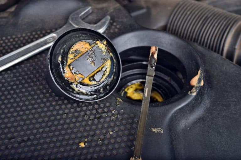 The thick, greasy yellow motor oil under oil cap as signs and symptom of a blown head gasket. Broken a car. - How Long Does It Take To Replace A Head Gasket?