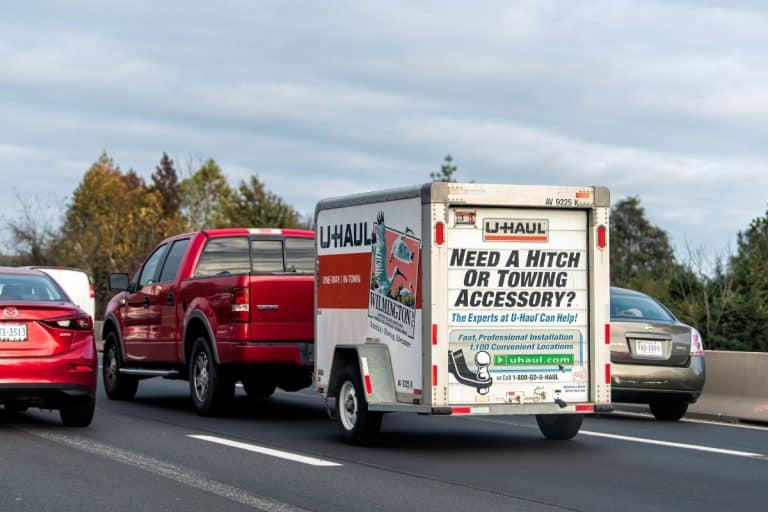 U-Haul trailer attached to Ford F-150 pickup truck with cars in traffic relocating moving from North Carolina to Virginia. - Do You Need A Trailer Hitch For Uhaul? What If You Don't Have One?