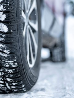 Detail of car tires in winter on the road covered with snow, Should Winter Tires Be Narrower?