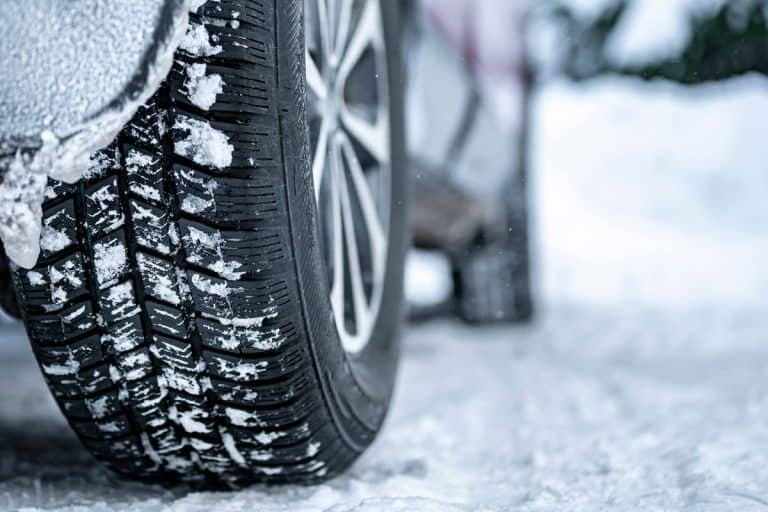 Detail of car tires in winter on the road covered with snow, Should Winter Tires Be Narrower?