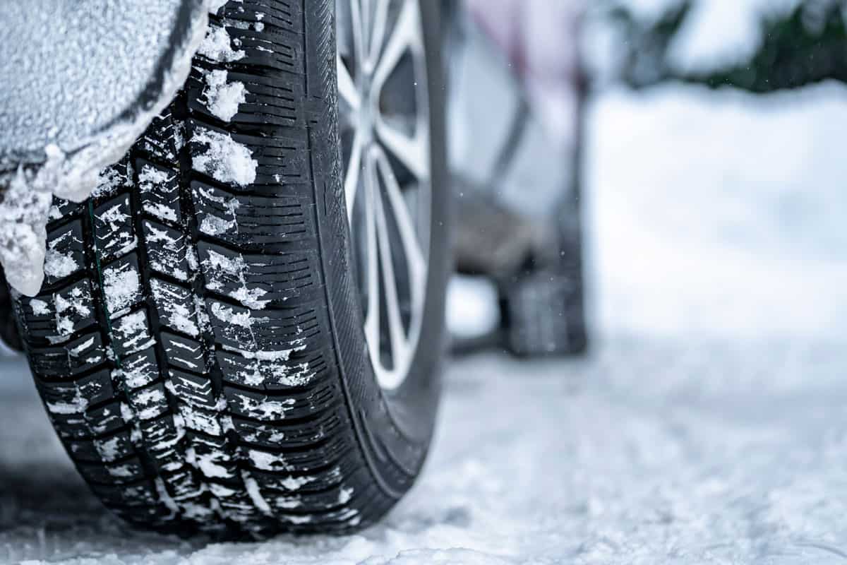 Detail of car tires in winter on the road covered with snow