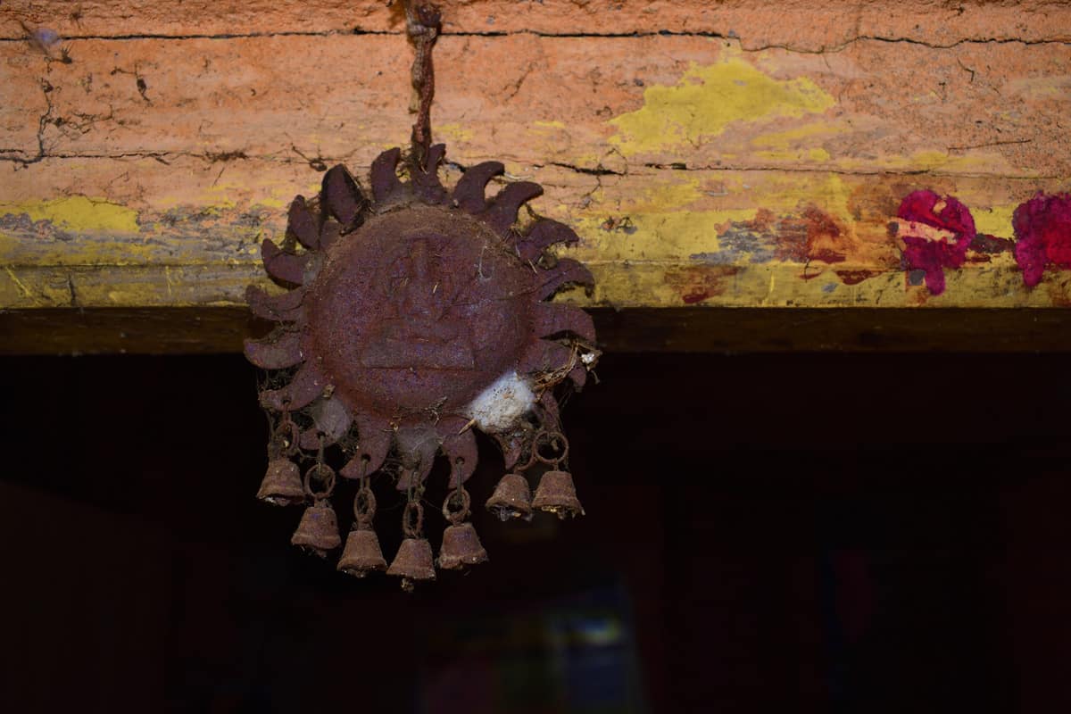 a close up shot of an old rusted steel made sun shaped structure with tiny bells