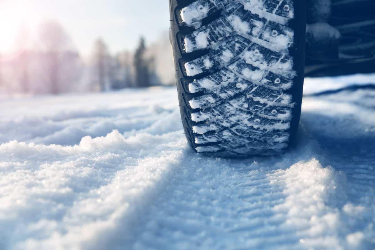 Car tires in winter on the road covered with snow