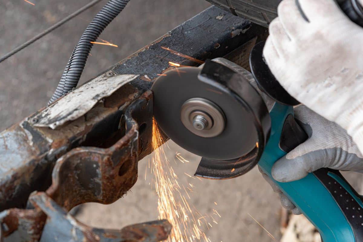 close up of a worker grinding off a piece of metal from a hitch
