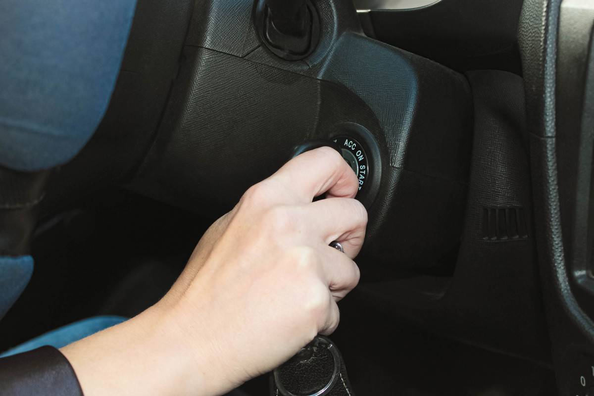 female hand starts the car with the ignition key