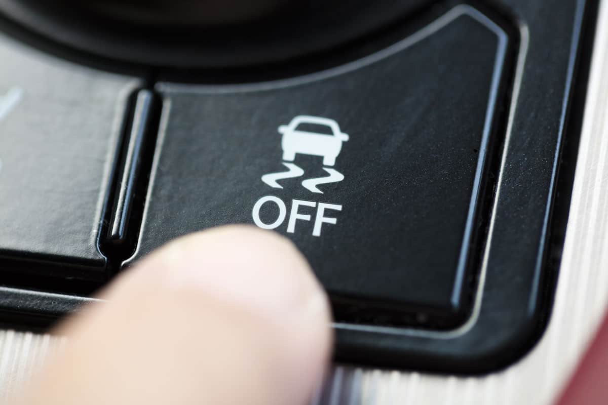 finger pressing traction control system button