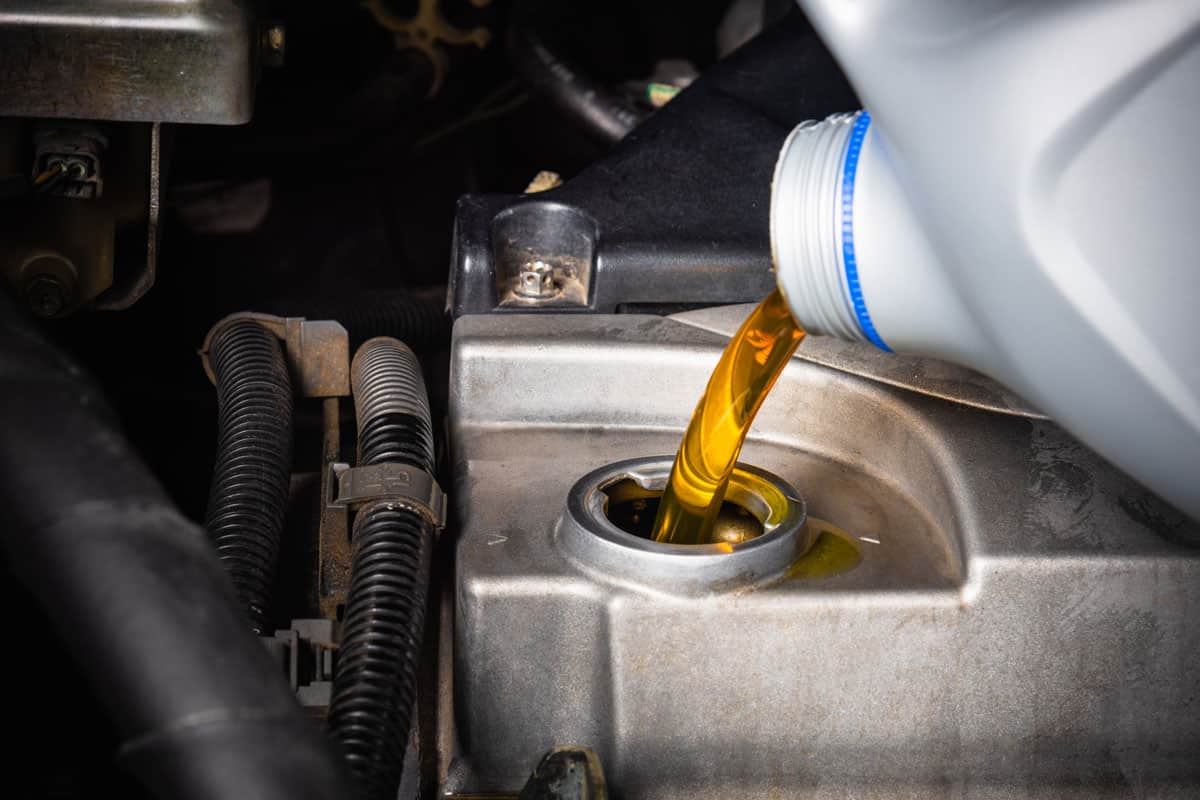 refueling and pouring from bottle to change lubricant oil at maintenance repair service station