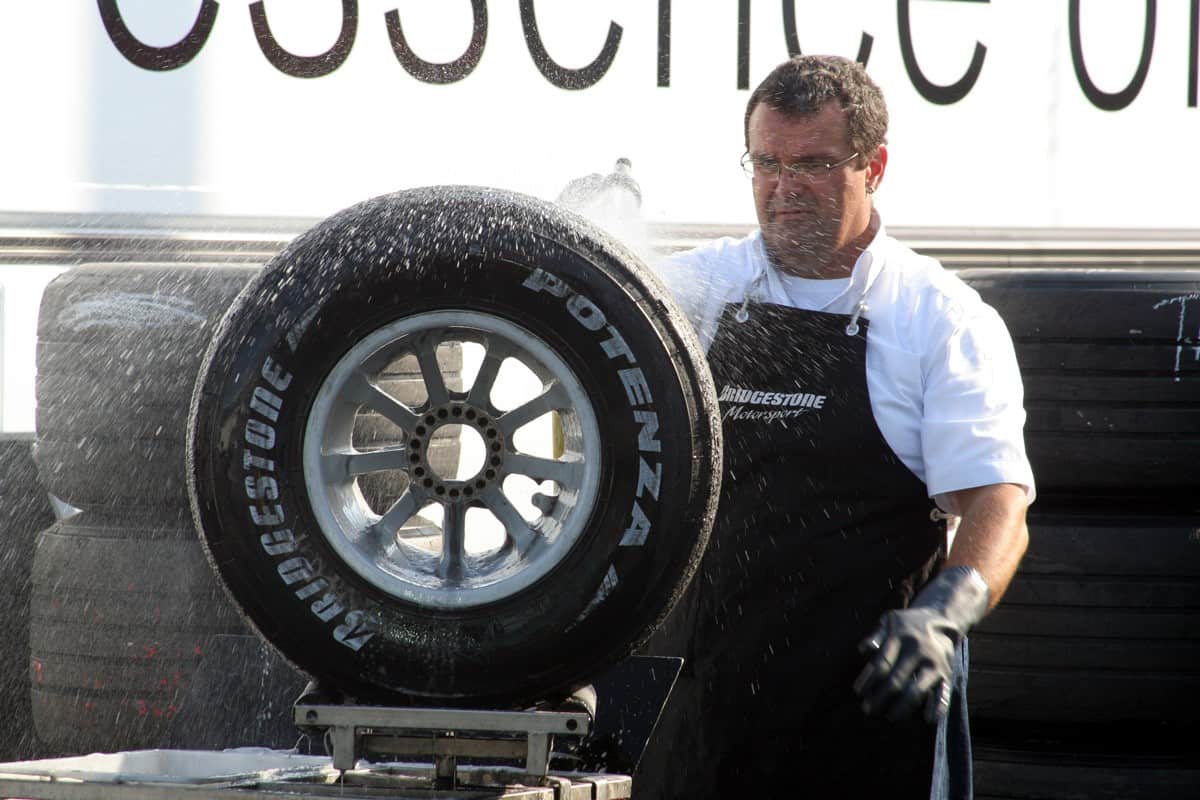 A crew member washes down a Formula 1 wheel to prepare for the new season of Formula 1 racing on March 14, 2010.