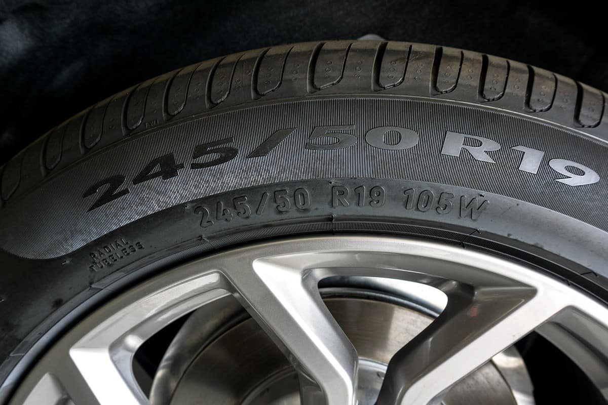 Number code on sidewall of car tyre with alloy wheel