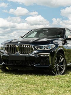 A black BMW M3 parked near a corn plantation, Do I Need To Get My BMW Serviced At BMW?