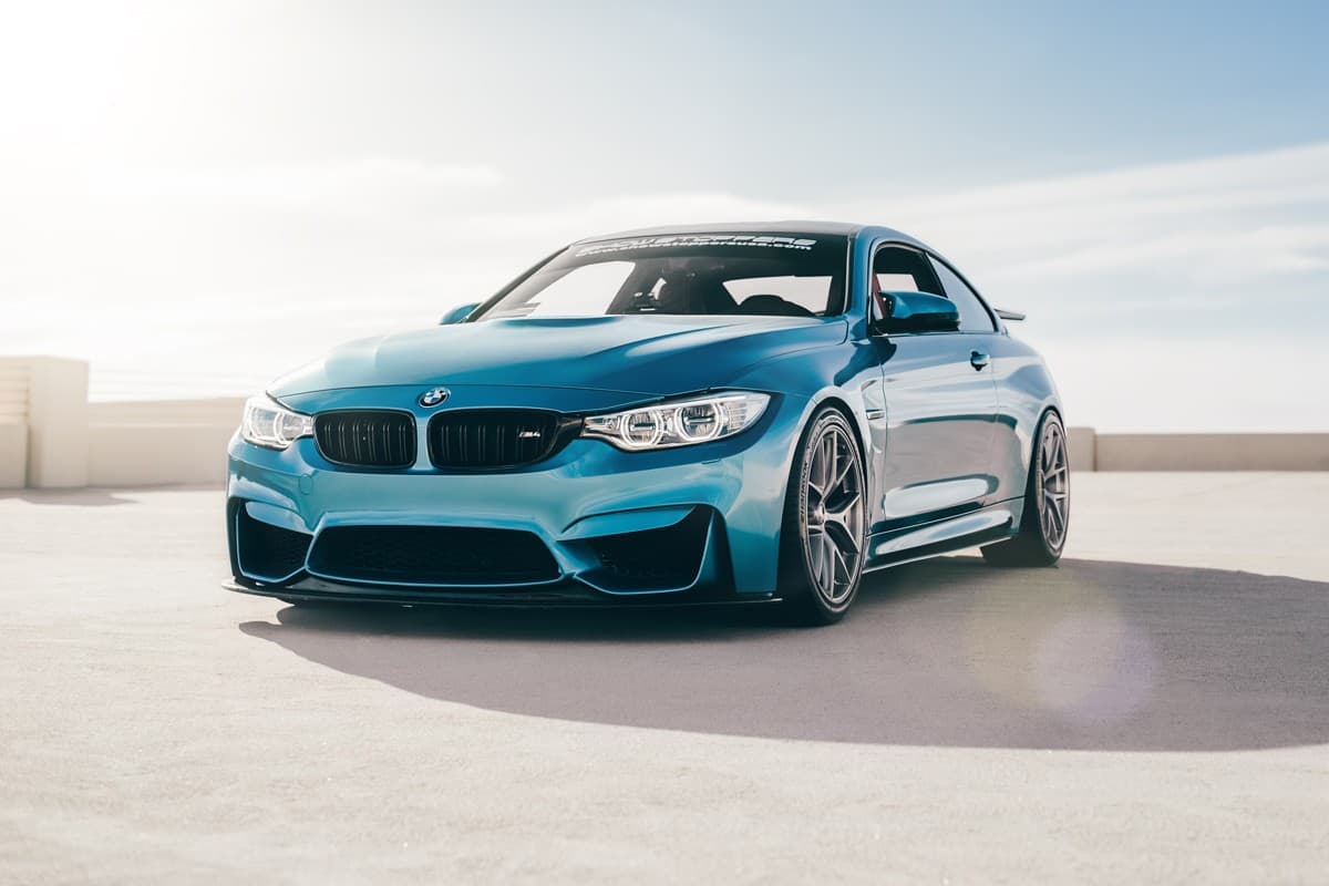 A bright blue colored BMW M3 photographed on the rooftop of a building
