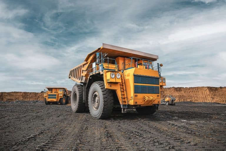 Large quarry dump truck. Big yellow mining truck at work site. Loading coal into body truck. Production useful minerals. Mining truck mining machinery to transport coal from open-pit production, The Largest Trucks on Earth