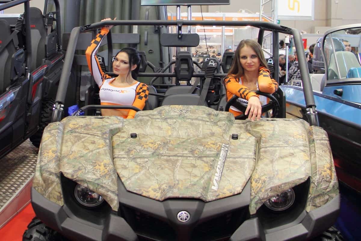 Moscow Russia – 03 02 2019 Camouflage ATV Yamaha Viking 6 with show girls on display stand on exhibition Hunting and fishing - 2019 at VDNH (VVC, ENEA) 