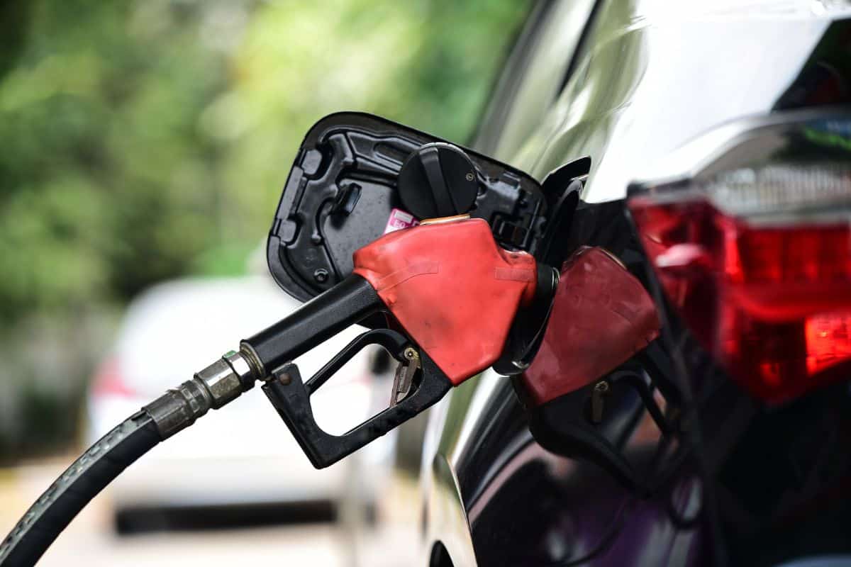 Refueling Car fill with petrol gasoline at gas station and Petrol pump filling fuel nozzle in fuel tank of car.
