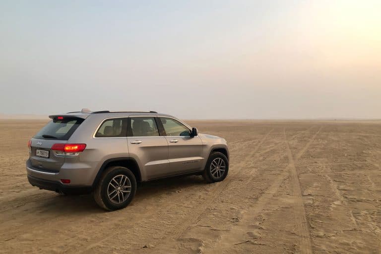 View of Jeep Grand Cherokee car in Desert Safari Camel Ride, a landmark for desert activities, Jeep Grand Cherokee Power Liftgate Is Not Working - Why? What To Do?