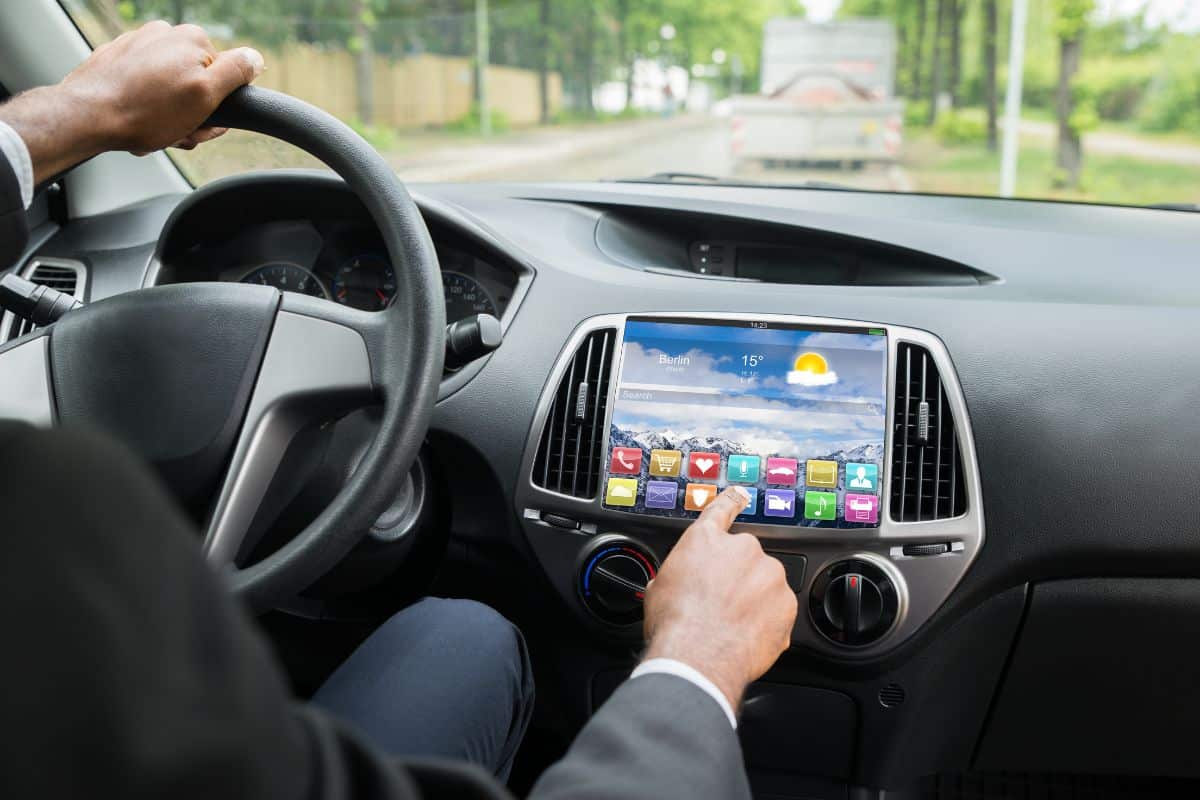 Close-up Of Person's Hand Using Colorful Application On Screen While Driving Car