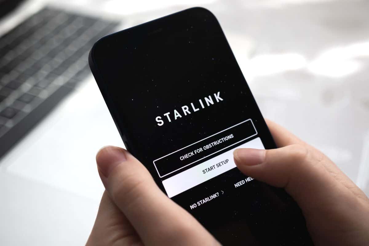 Mobile phone with Starlink app Internet, logo close-up view