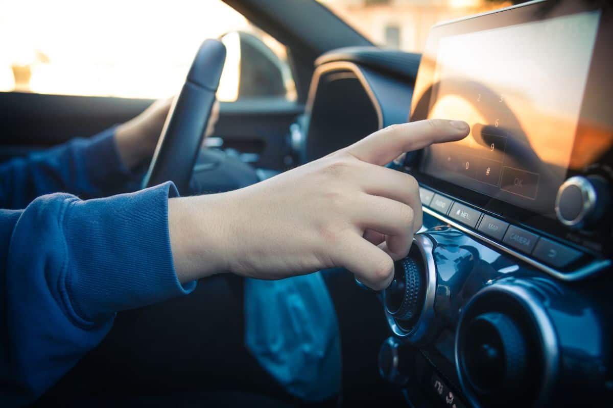 Teen drive a car and use infotainment. Young man reading messages and make phone call while driving. Dangerous behavior, accident risk. Danger, transgression, youth, distraction concept