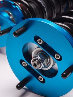 auto suspension tuning coilovers shock absorbers and springs blue for a sports drift car on a white background