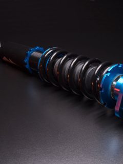 An up close photo of a coilover on a dark background, The Ultimate Showdown: Coilovers vs. Struts